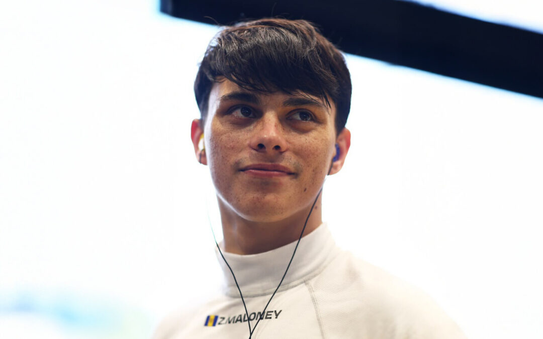 Zane Maloney smiling wearing a white undershirt with his ear pieces in.